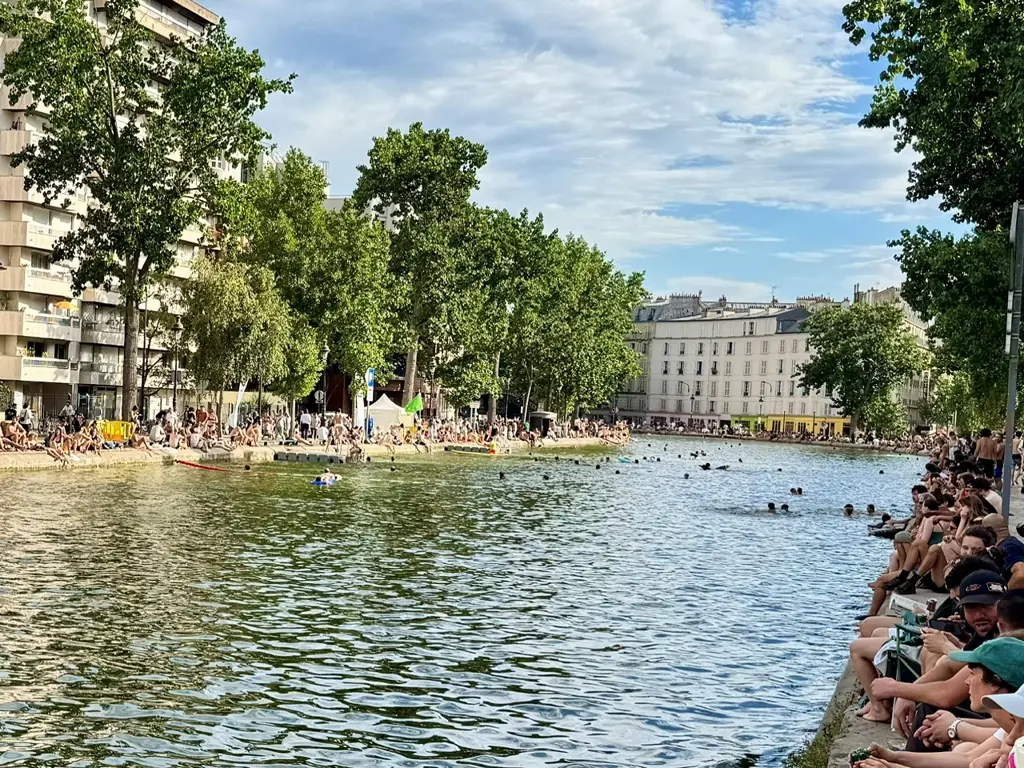 Le canal saint Martin, les quais sont bondés de parisiens cherchant la fraîcheur, et des nageurs profitent de la baignade en eaux vives désormais possible.