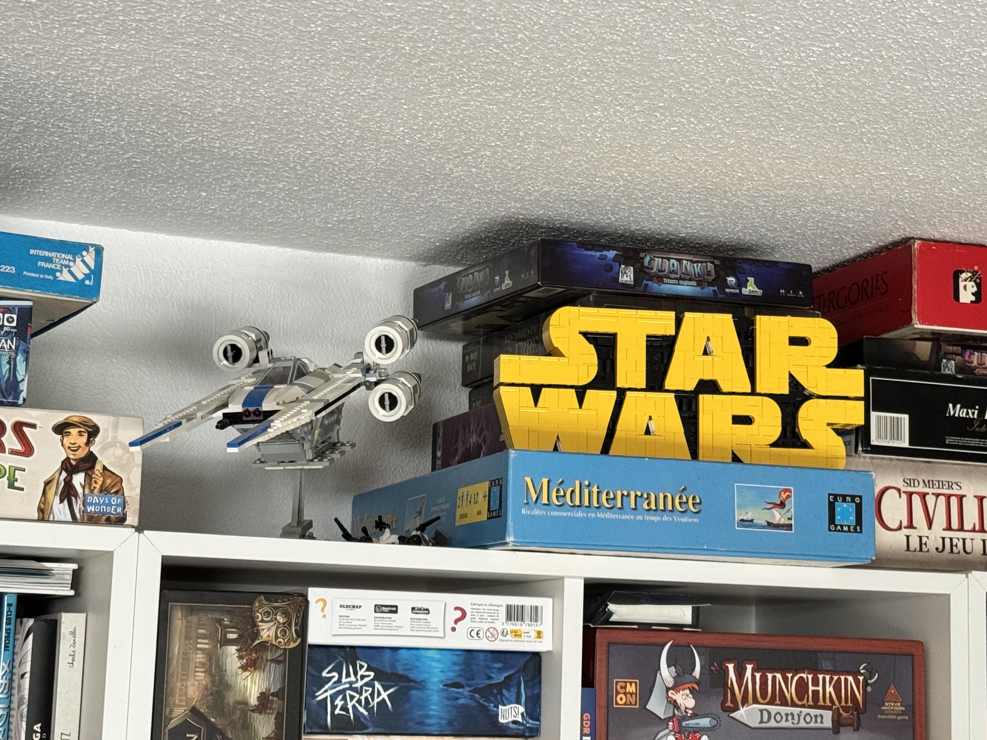 Au-dessus de mes étagères, un vaisseau Star Wars lego (et un logo Star Wars lego… et des jeux de société !)