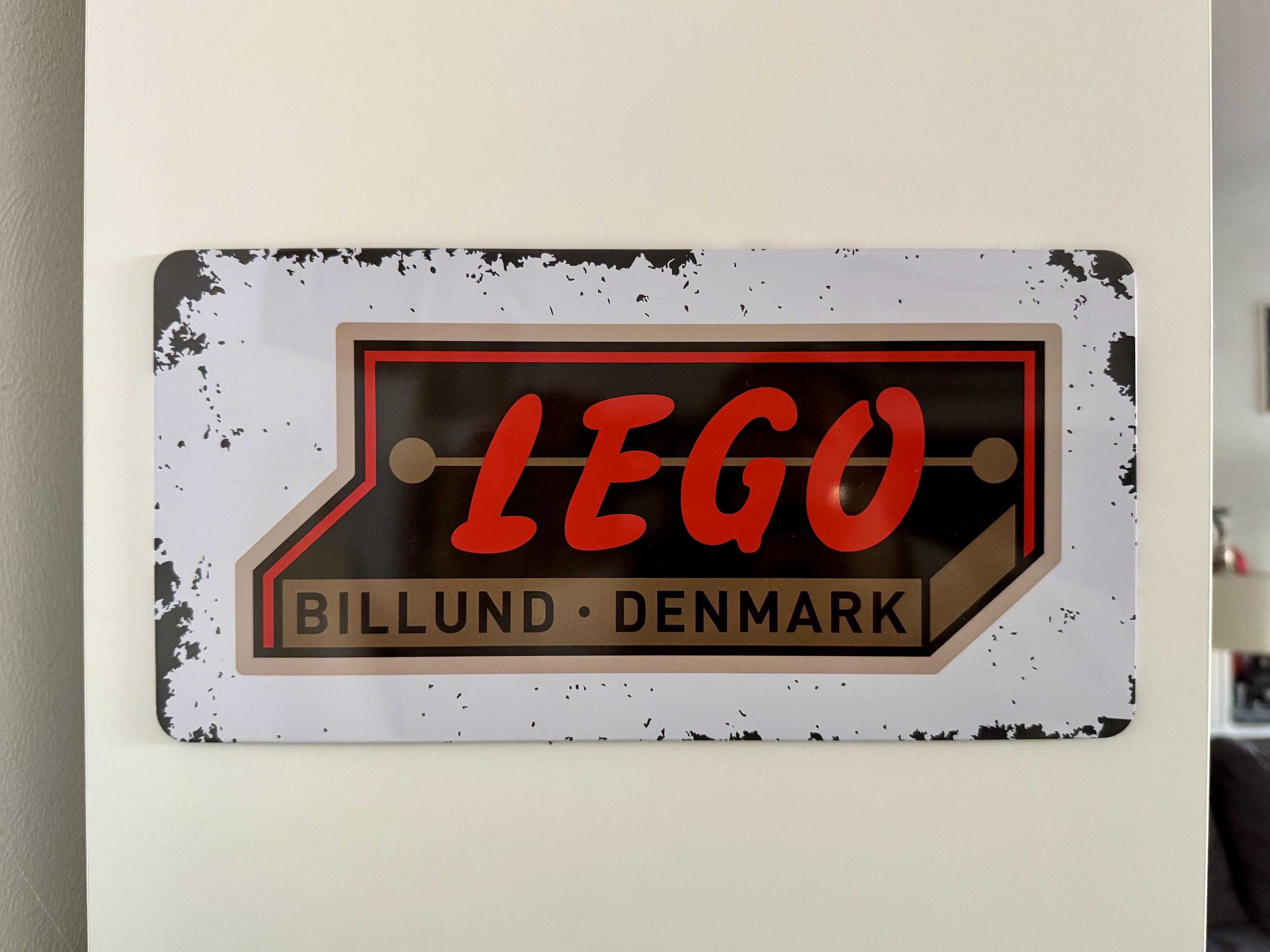 Une plaque en métal avec un (vieux) logo « Lego » rouge et, en dessous l’inscription « Billund Denmark »